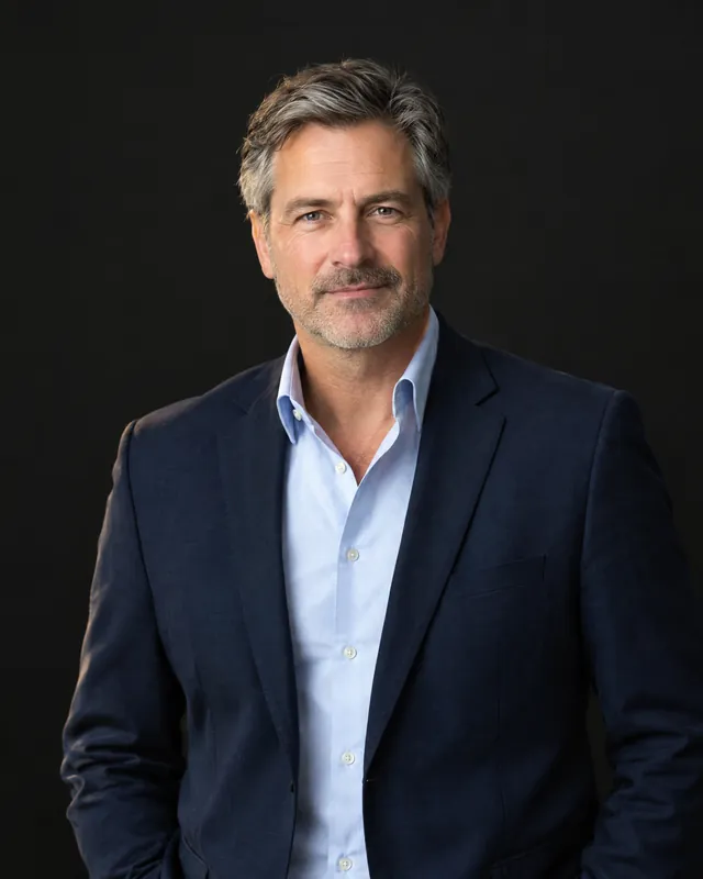 Managing director of a mid-size company in a navy jacket